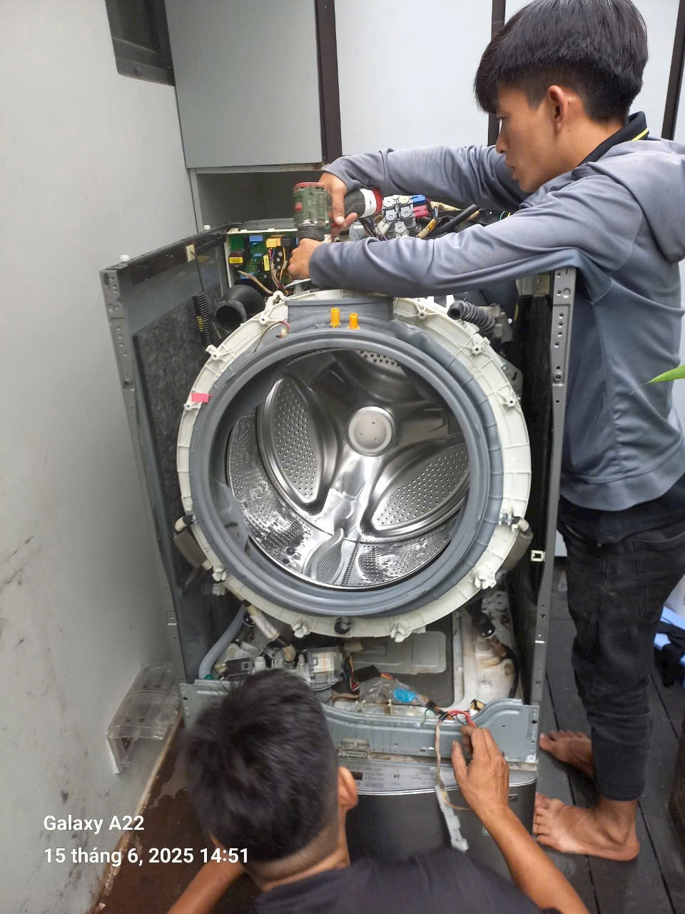Kỹ thuật viên đang kiểm tra và sửa chữa máy giặt tại nhà